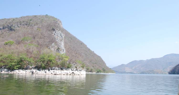 Une rivière calme avec des montagnes en arrière-plan.