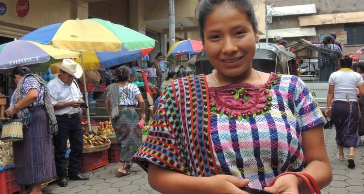 Mujer con atuendo tradicional en un bullicioso mercado.