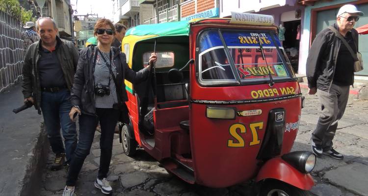 Turistas posando con un colorido tuk-tuk.