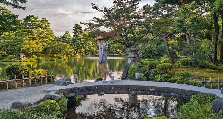 Personne traversant un pont de jardin japonais paisible
