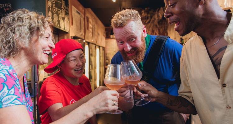 Un petit groupe trinque avec des verres de vin dans un bar japonais confortable.