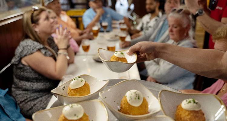 Grupo de personas degustando la cocina local en un evento gastronómico.