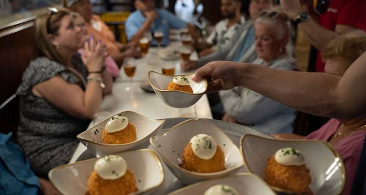 Grupo de personas disfrutando de una comida con tapas en la mesa.
