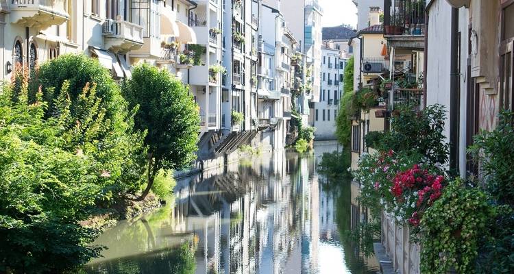 Línea de edificios junto a un canal tranquilo.