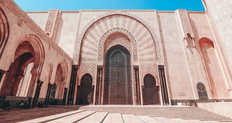 Fachada intrincada de una mezquita con puertas grandes.