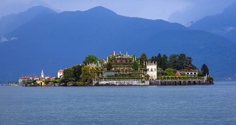 Une île avec des jardins élaborés et des bâtiments historiques entourée par un lac.