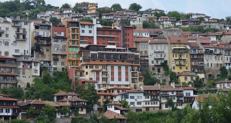 Ville colorée à flanc de colline avec des styles architecturaux variés.