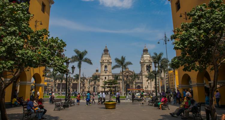 Place Mayor animée à Lima avec des palmiers, des bâtiments coloniaux et des foules profitant de la place.