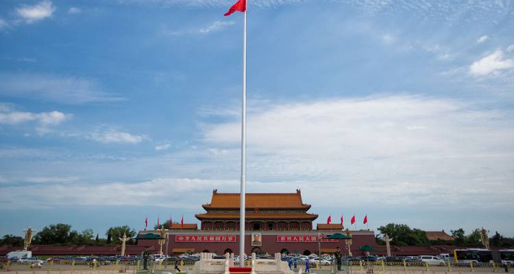 La Plaza de Tiananmen con el asta de bandera y la Puerta de la Paz Celestial bajo un cielo brillante.