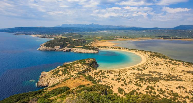 Baie côtière pittoresque aux eaux turquoise et au rivage sablonneux.