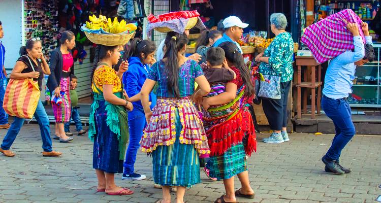 Busy street scene with locals carrying baskets and produce in traditional attire