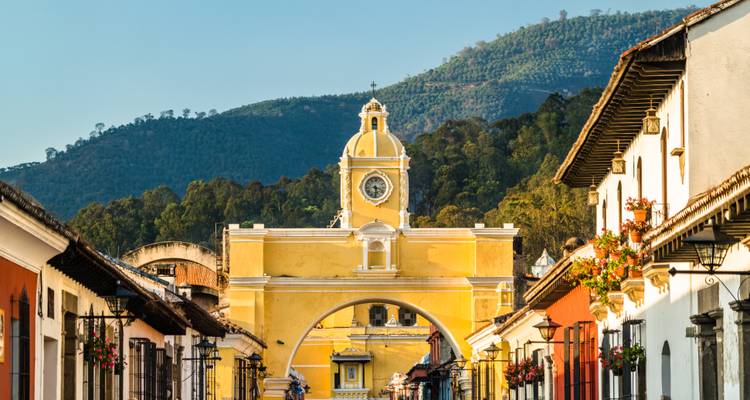 Iconic yellow Santa Catalina Arch and clock tower framed by colonial streets of Antigua