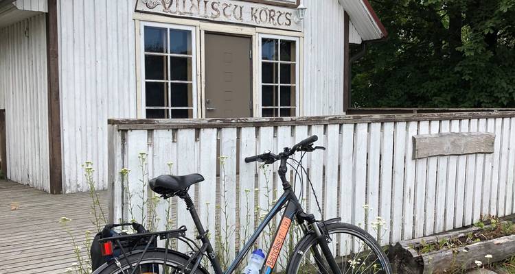 Vélo garé devant un bâtiment en bois fermé.