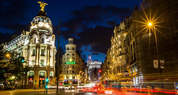 Métropole illuminée - traînées de feux tricolores du bâtiment et de la Gran Vía sous un ciel nocturne bleu profond
