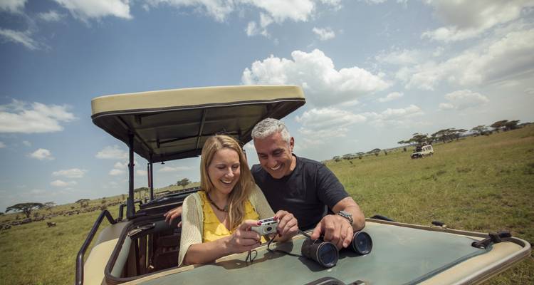 Couple dans un véhicule de safari observant la faune.
