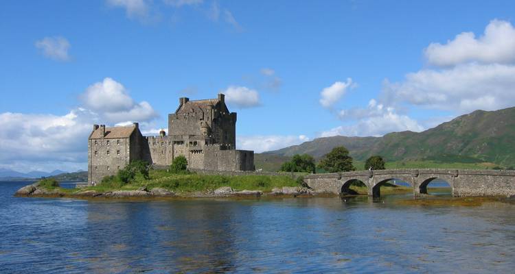 Un château historique sur une petite île relié par un pont de pierre.