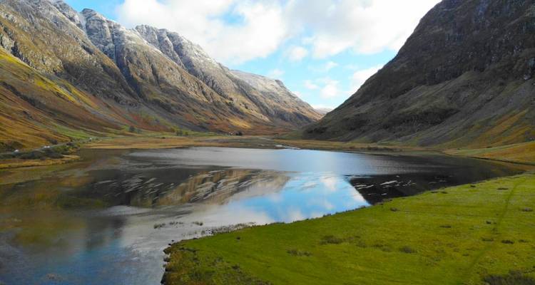 Un lac réfléchissant entouré de hautes montagnes.