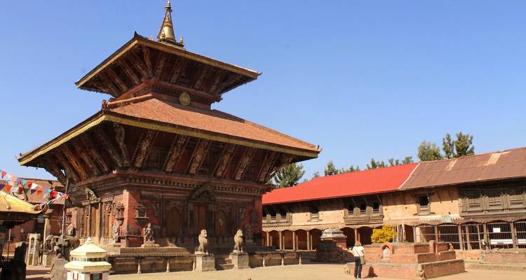 Templo pagoda tradicional de varios pisos con intrincadas tallas de madera que se destacan contra el cielo azul cristalino de Katmandú.