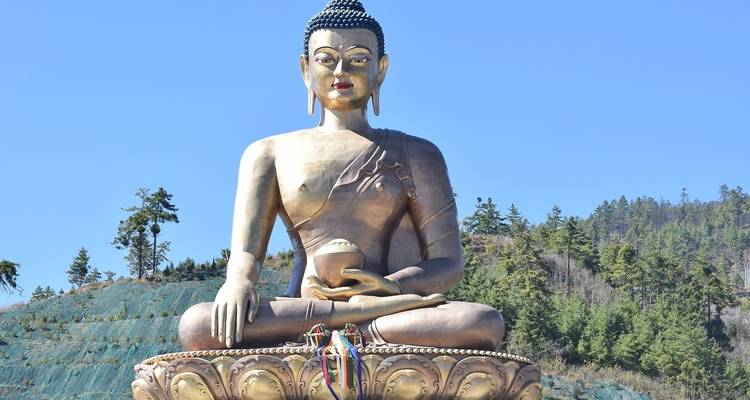 Estatua gigante de Buda en una ladera montañosa abierta.