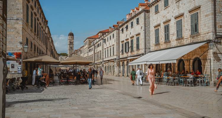 Voetgangersstraat in Dubrovnik met cafés en wandelende mensen.