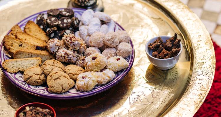 Plato de galletas tradicionales variadas en una bandeja dorada.