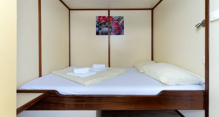 Kabinenraum mit Doppelbett und minimaler Dekoration.