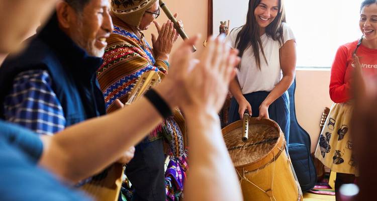 People engaged in a musical activity, playing drums and panpipes.