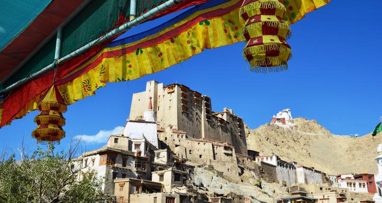 Monastère avec drapeaux colorés dans un cadre montagneux.