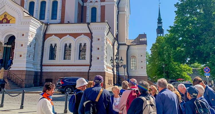 Un groupe de touristes se rassemble à l'extérieur d'une cathédrale orthodoxe richement décorée pour une explication de la ville.