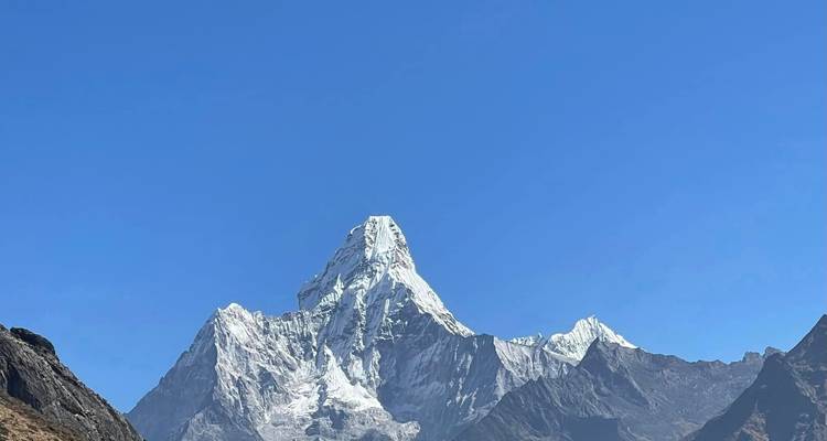 Scherp, geïsoleerd uitzicht op de iconische met sneeuw bedekte top van Ama Dablam die een diepblauwe Himalayaanse hemel doorboort.