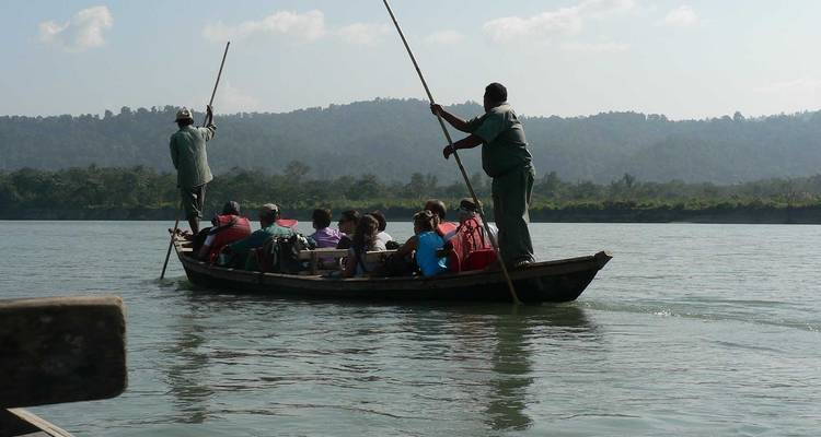 Menschen in einem traditionellen Boot rudern auf einem Fluss.