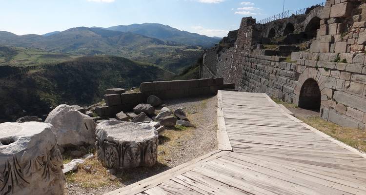 Ruinas de ciudad antigua con vista sobre el valle y las montañas.