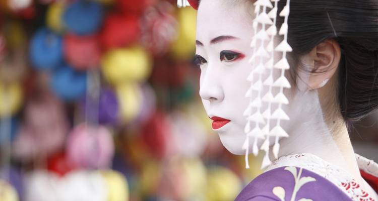 Portret van een traditionele geisha in kleurrijke kledij.