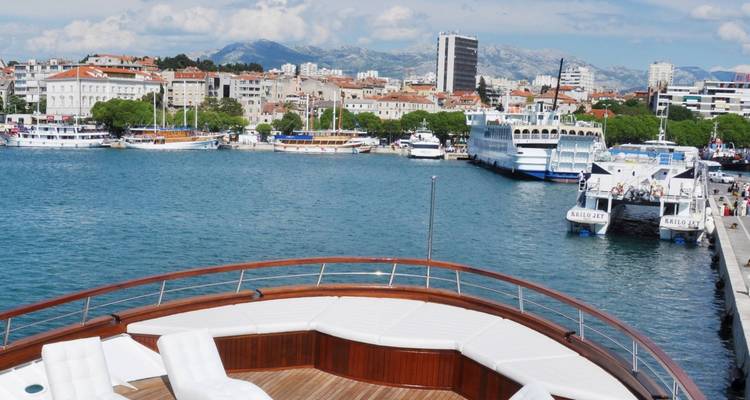 Blick von einem Schiff, das sich einer Küstenstadt und einem Hafen nähert.