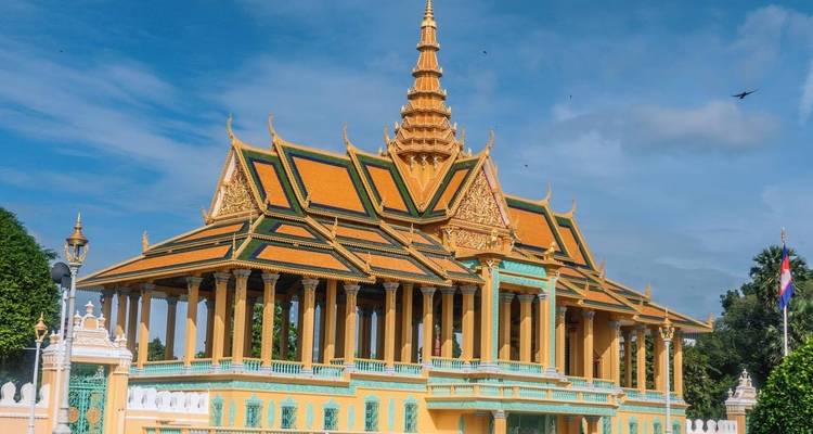 Ein großartiger Tempel mit kunstvollen goldenen und orangefarbenen Verzierungen unter einem klaren blauen Himmel.