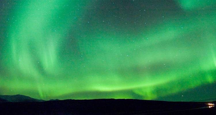 Vibrant display of the Northern Lights over a mountainous landscape.