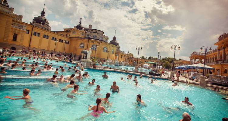 Piscinas al aire libre de los Baños Termales Széchenyi de Budapest llenas de bañistas disfrutando de las aguas cálidas.