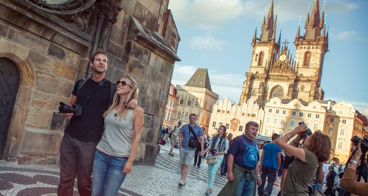 Multitudes de turistas se mezclan en la Plaza de la Ciudad Vieja de Praga bajo las dos torres gemelas de la Iglesia de Týn.