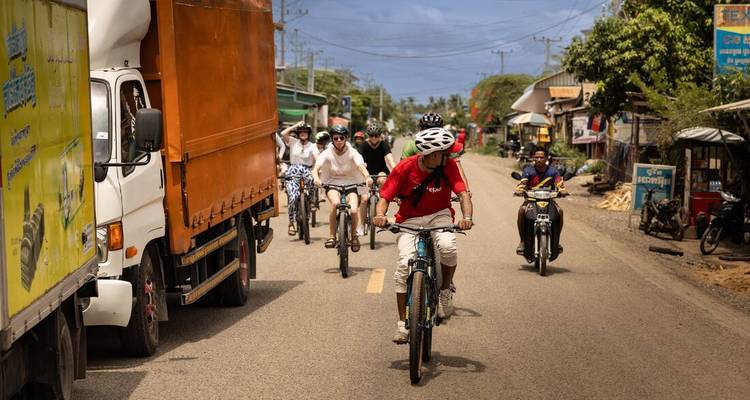 Grupo de personas en bicicleta por una calle en Camboya.
