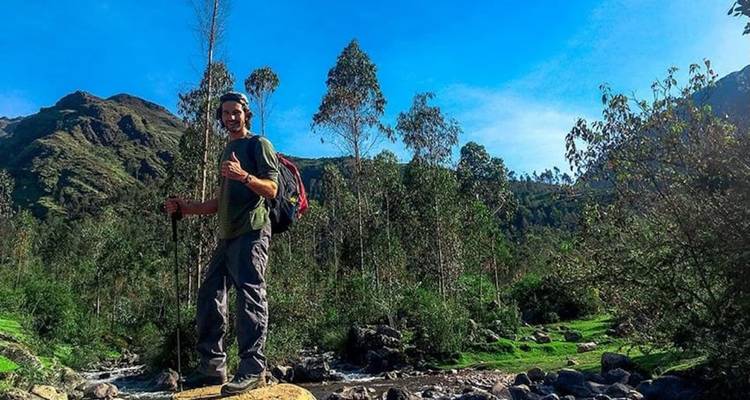 Excursionista de pie con un fondo escénico de montañas.