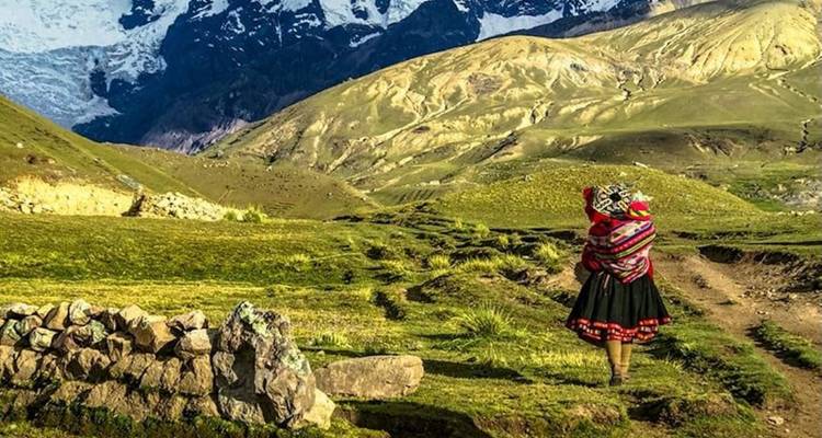 Persona con ropa tradicional en paisaje montañoso.