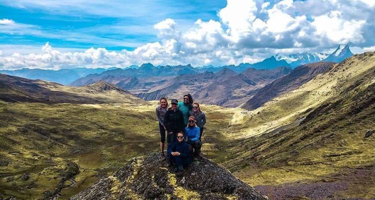 Grupo en la cima de una colina con vista panorámica de las montañas.
