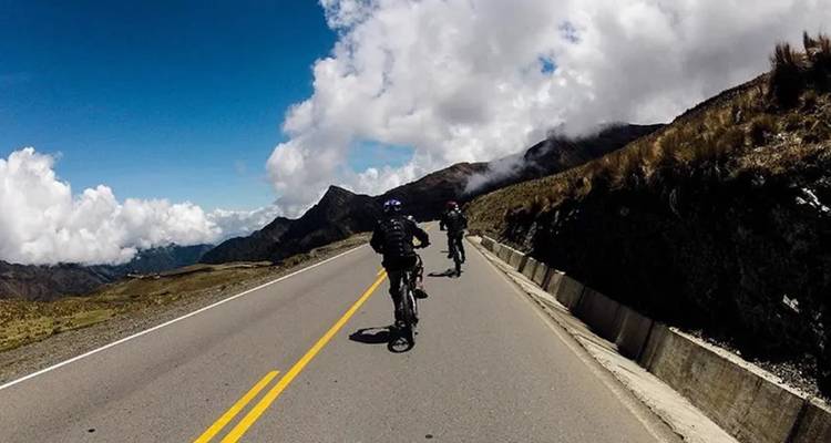 Ciclistas pedaleando en una carretera a través de un paisaje montañoso.