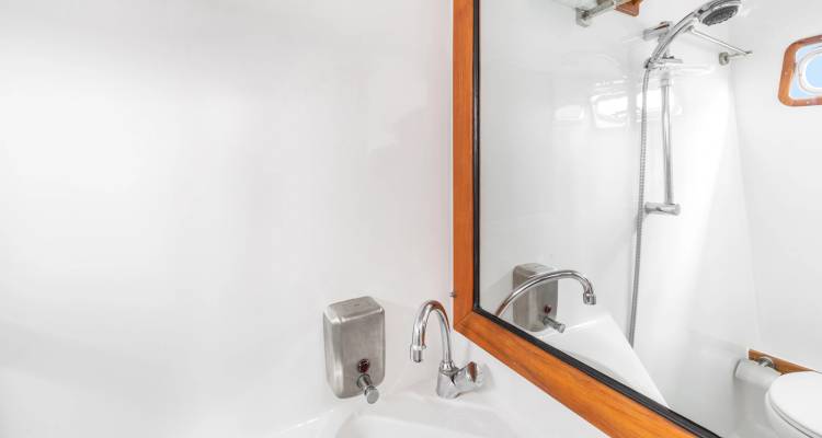 Salle de bains de yacht propre avec miroir et accessoires en acier inoxydable.