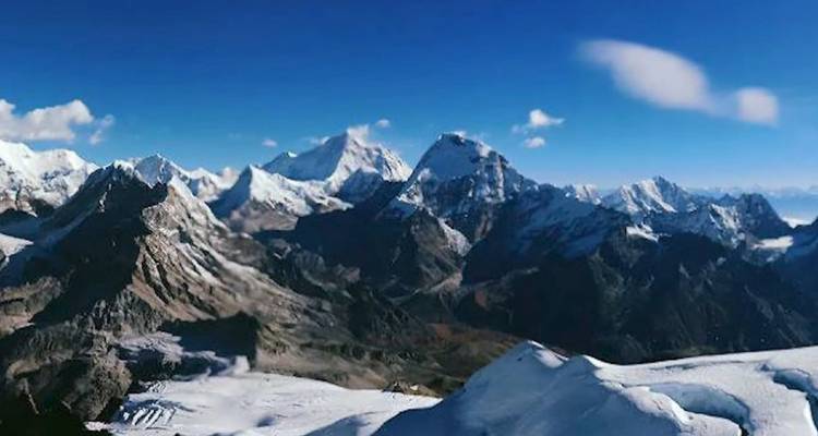 Vue panoramique d'une chaîne de montagnes aux sommets enneigés.