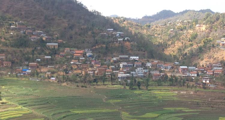 Campos aterrazados y pueblo en un terreno accidentado.