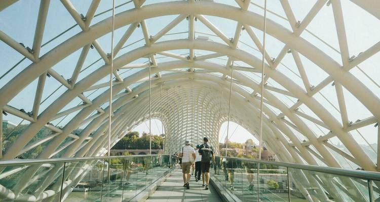 Des gens marchant sur un pont moderne et architectural.