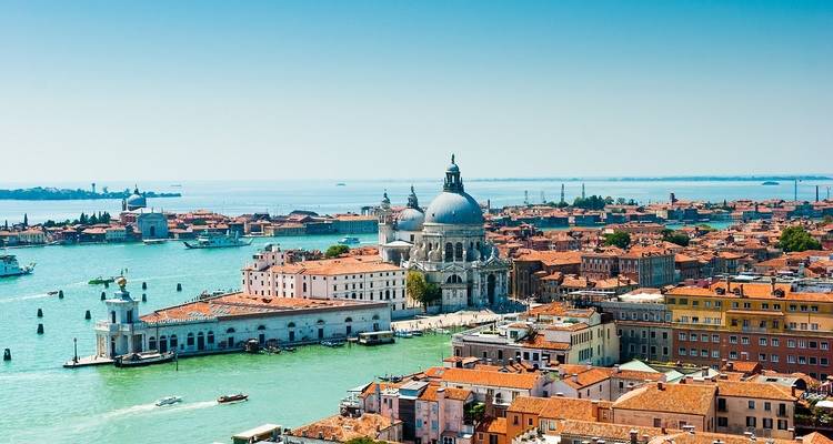 Vue aérienne de Venise avec des eaux bleues et des bâtiments historiques.