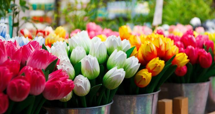 Emmers die overloopend zijn met felgekleurde kunstmatige tulpen in een marktopstelling.