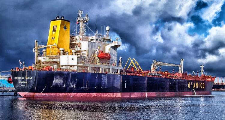 Grote vrachtschip aangemeerd in een haven onder dramatische onweerswolken.